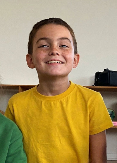 Lachender Junge in einem gelben T-Shirt